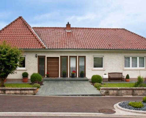 Weißes Einfamilienhaus in Ehnen mit moderner Alu braunen Coplaning Haustür und braunen Coplaning Alu Fenster mit integrierten Jalousien.