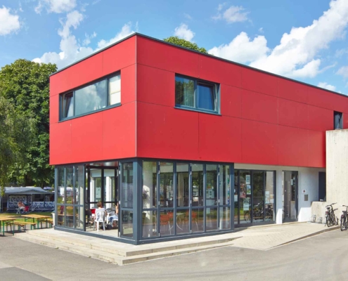 Restaurant mit einer Coplaning Terassenveranda mit einer Glasfaltwand und einer grauen geöffneten Alu- Faltanlage.