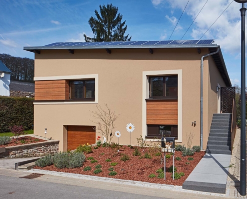 Braunes Einfamilienhaus mit modernen braunen Coplaning Alu Fenster und einem Coplaning Garagentor aus Holz.