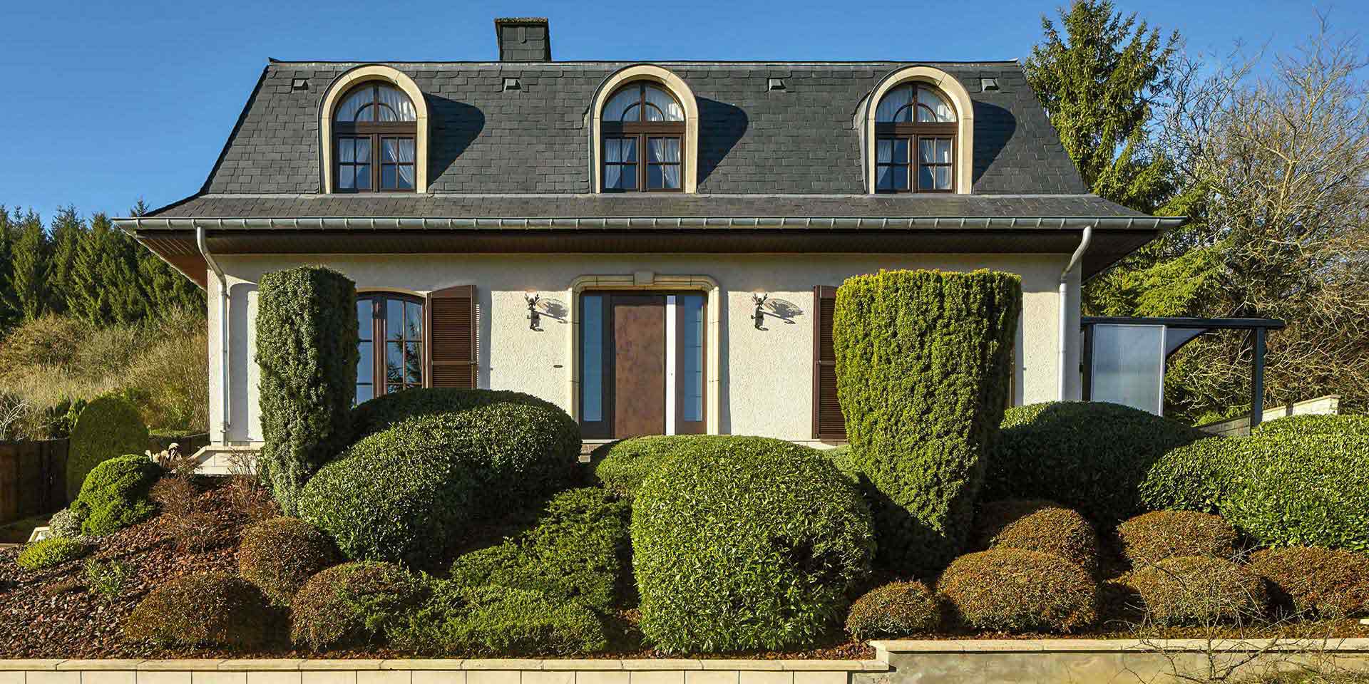 Gelbliches Einfamilienhaus mit edler brauner Coplaning Keramikhaustür.