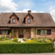 Einfamilienhaus mit Klinkerfassade mit einer braunen klassischen Coplaning Haustür und braunen Coplaning PVC Alu Fenster.