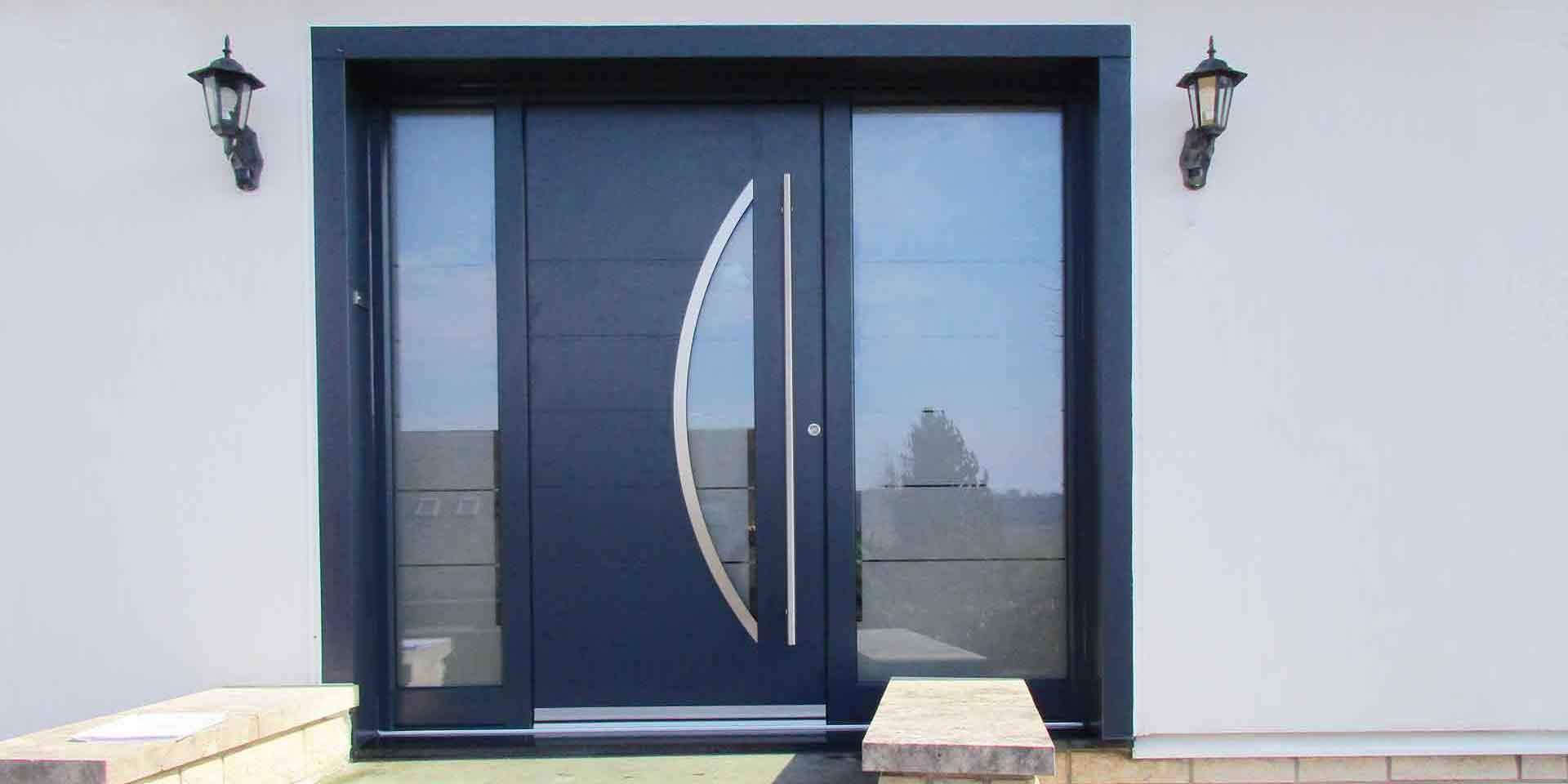 Nahaufnahme des Eingangsbereiches eines weißen Einfamilienhauses mit Blick auf eine graue Coplaning Aluminium Lack Haustür.