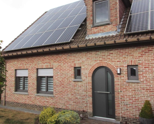 Vorderseite des Einfamilienhauses mit Steinfassade mit moderner grauen Coplaning Haustür.
